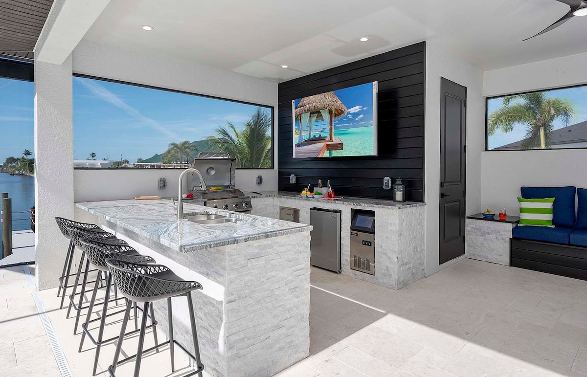 Privater Poolbereich am Kanal mit Bootsdock und Blick auf den Sonnenuntergang.