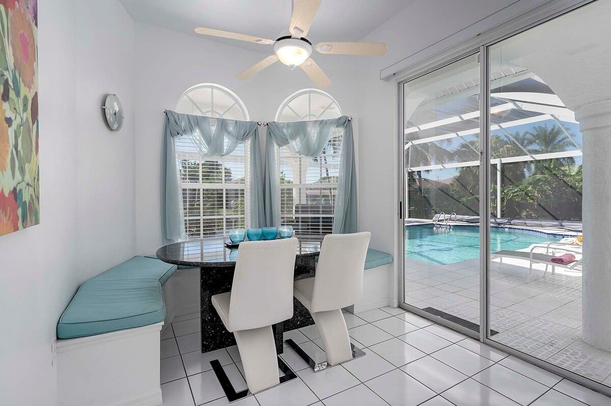 Außenbereich mit beheiztem Pool, Sonnenliegen und Blick auf den Kanal mit privatem Dock.