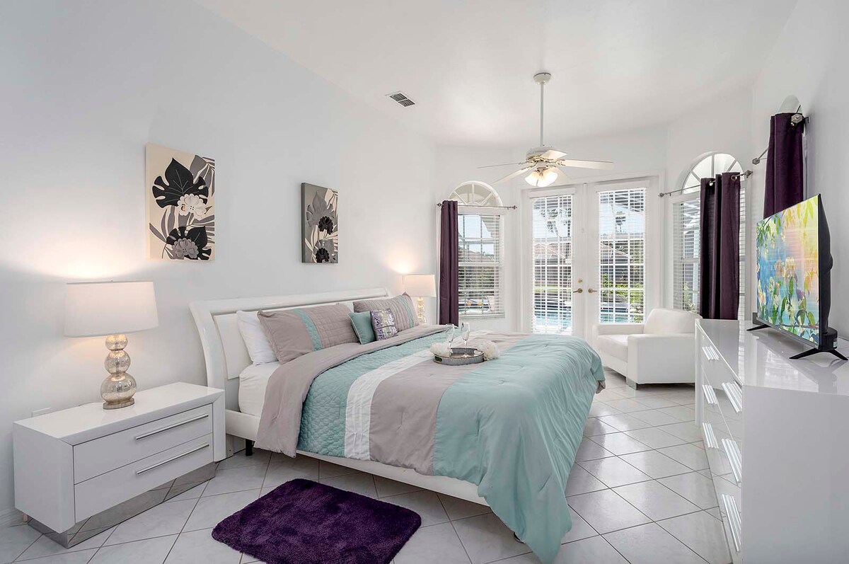 Beheizter Poolbereich mit Lanai, Sonnenliegen und Blick auf den Kanal mit privatem Dock.