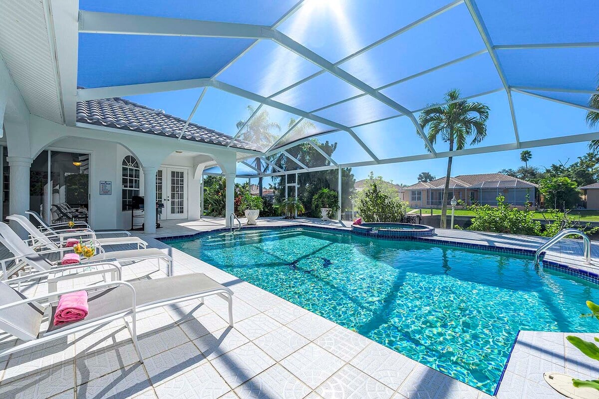 Beheizter Pool auf der sonnigen Terrasse mit Blick auf den Kanal und privatem Dock.