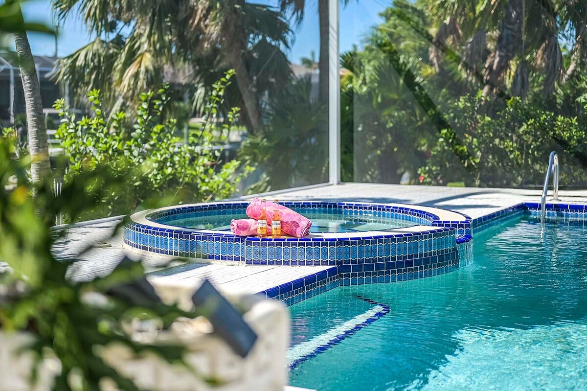 Beheizter Pool auf der Lanai mit Sonnenliegen und Blick auf den Kanal.