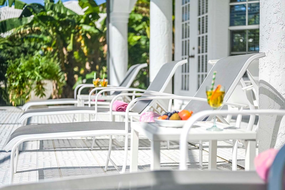 Außenbereich mit beheiztem Pool, Sonnenliegen und Blick auf den Kanal.