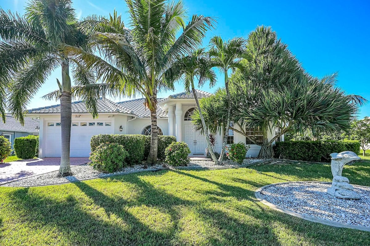 Außenbereich mit beheiztem Pool, Sonnenterrasse und privatem Dock am Kanal.