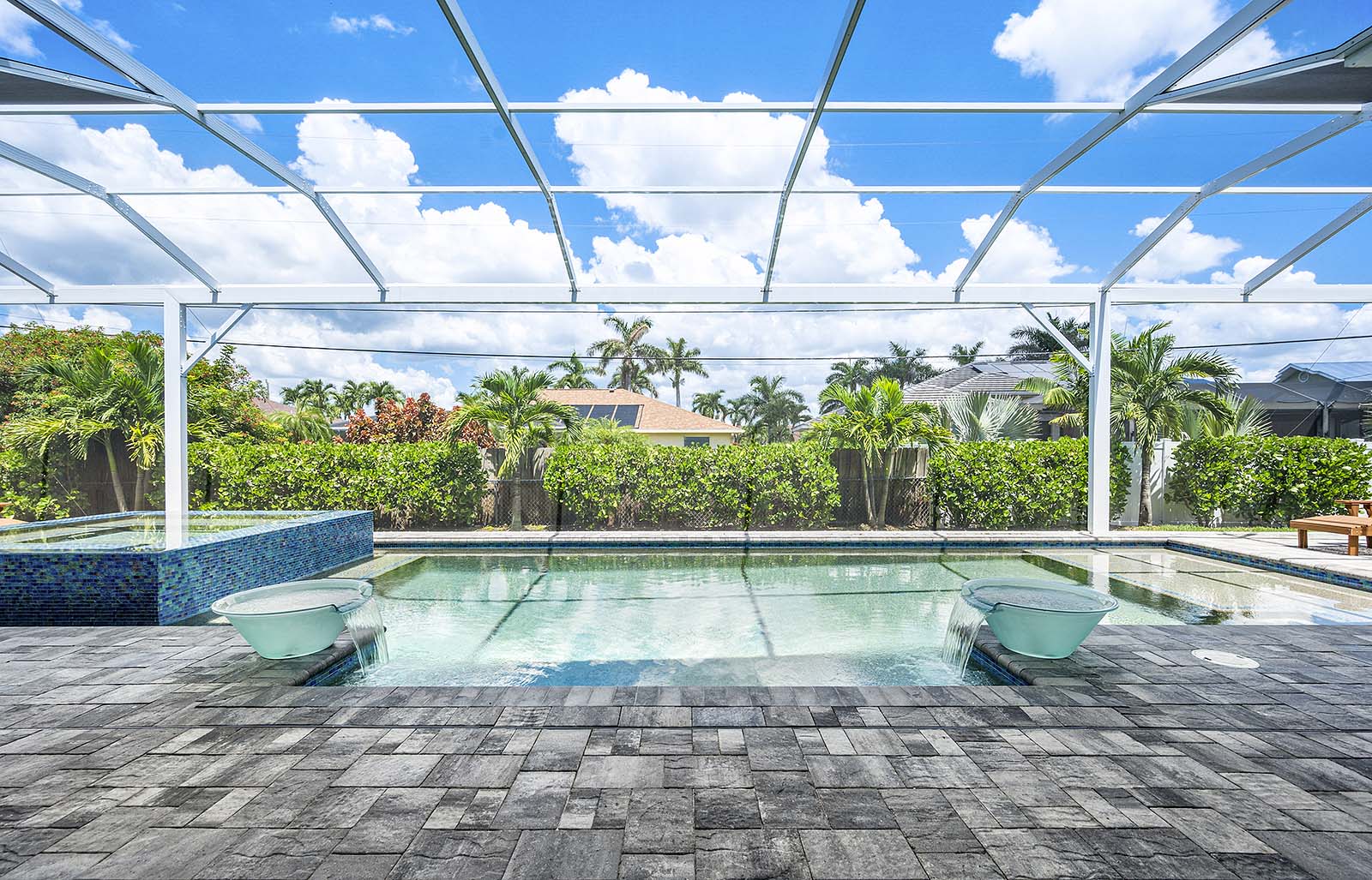 Überdachte Lanai mit Sitzbereich und Blick auf den Pool.