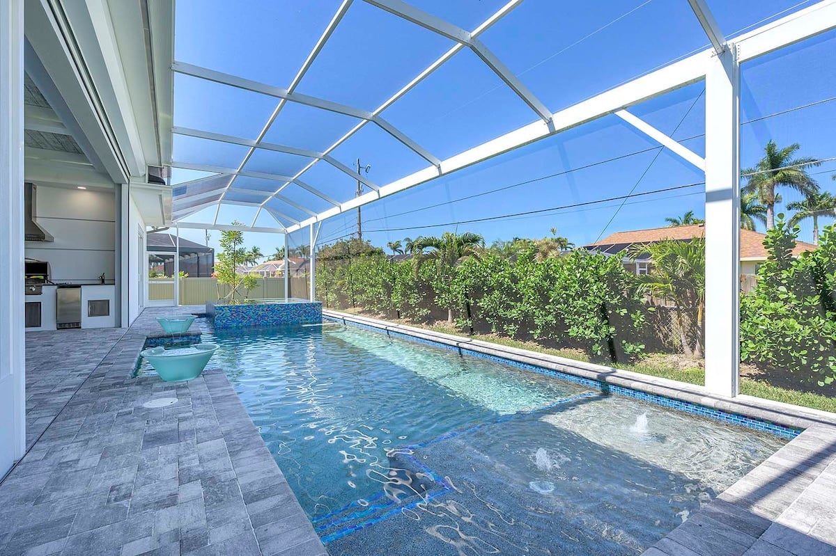 Überdachte Lanai mit Outdoor-Essbereich und Blick auf den Pool.