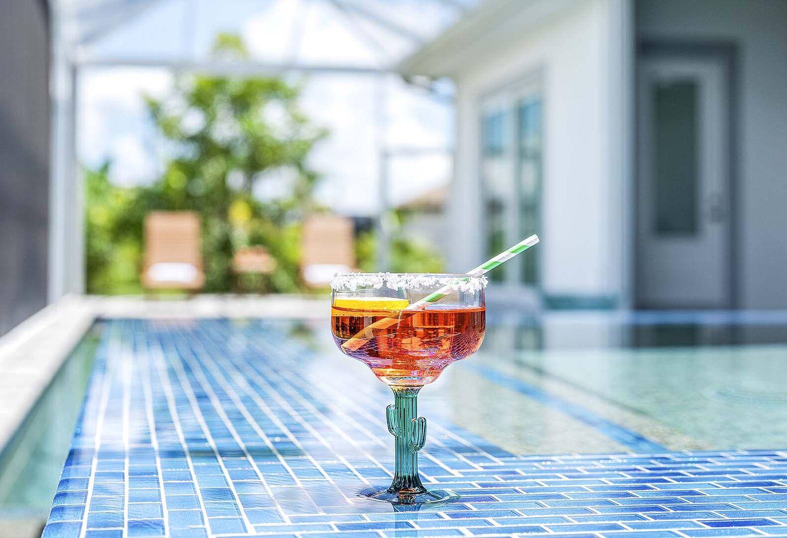 Überdachte Lanai mit Outdoor-Küche und Essbereich am Pool.