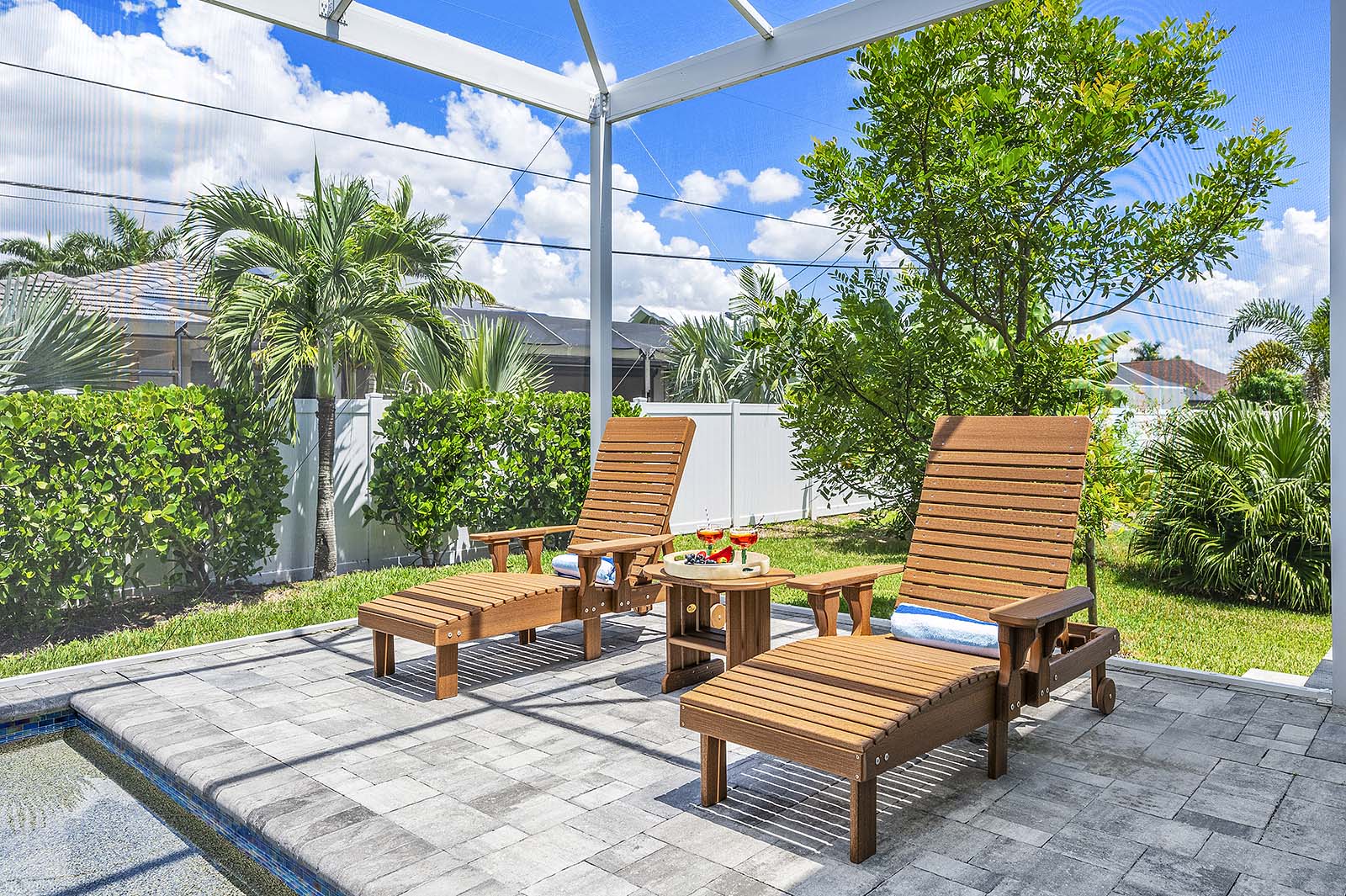 Überdachte Lanai mit Sitzbereich und Blick auf den Pool.