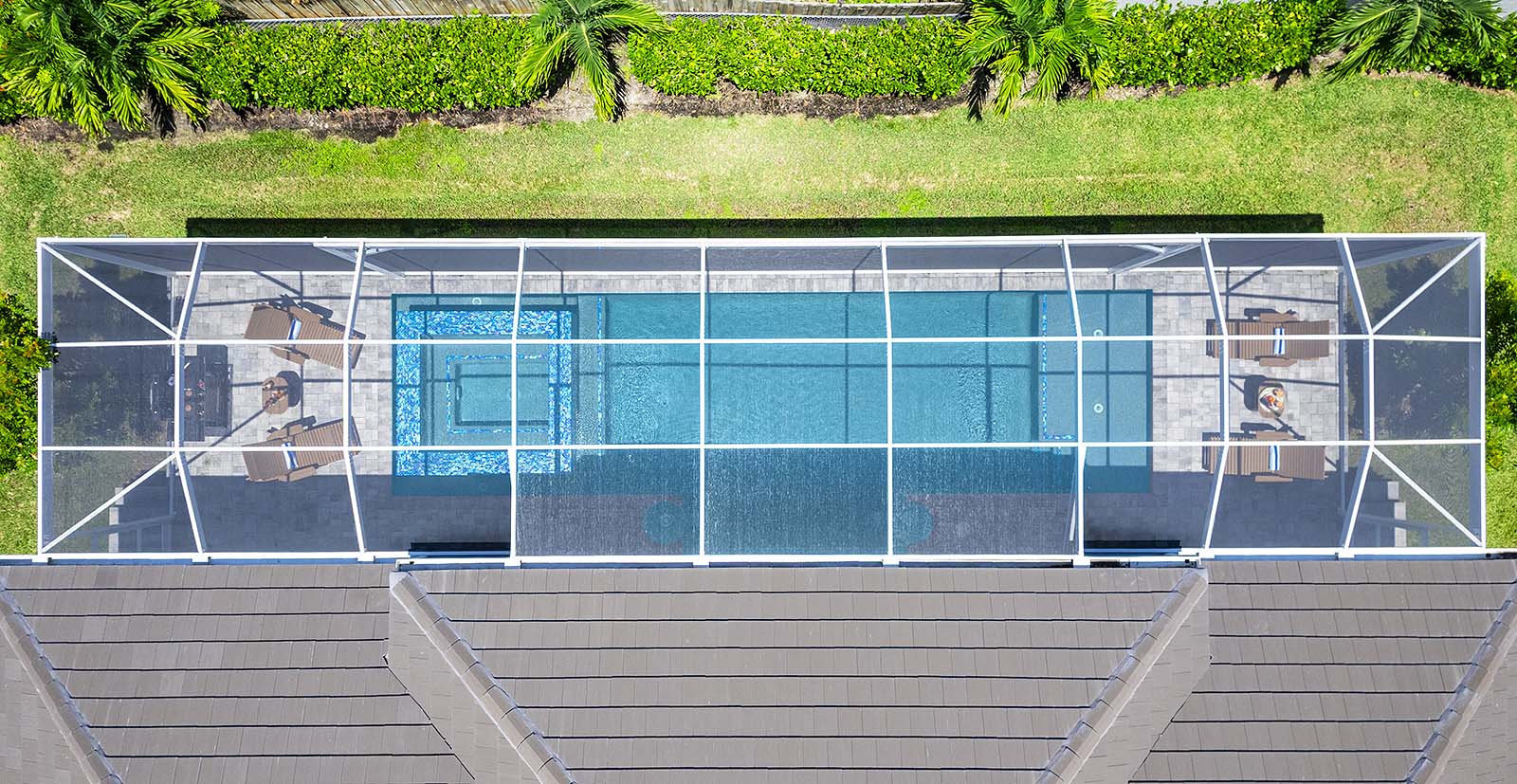 Überdachte Lanai mit Sitzbereich und Außen-Esstisch am Pool.