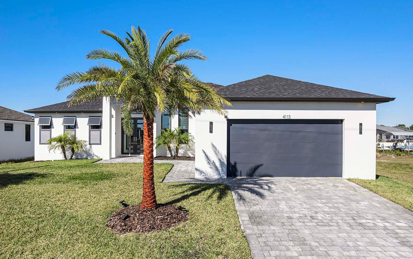 Terrasse am Kanal mit Grill und Feuerstelle bei Sonnenuntergang.