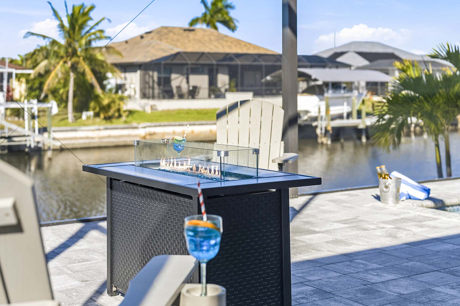 Große Terrasse am Kanal mit Grill, Feuerstelle und Sitzbereich bei Sonnenuntergang.