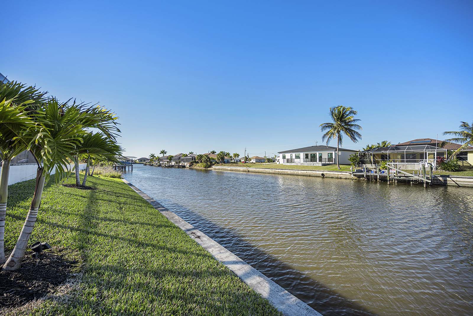 Große Terrasse am Kanal mit Grill, Sitzplätzen und Blick auf den Sonnenuntergang.