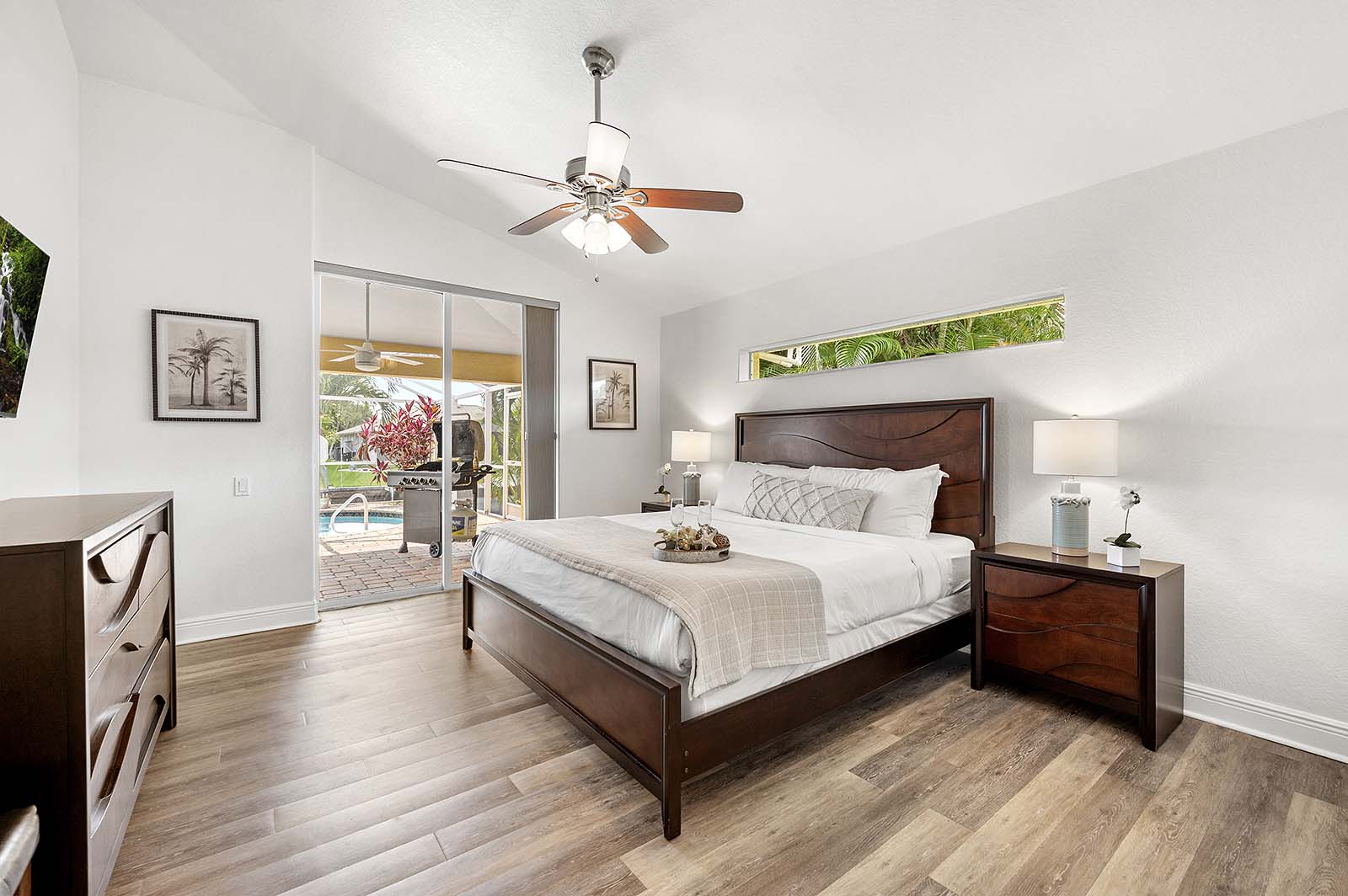 Privater Poolbereich mit Sonnenliegen und TV am Kanal.