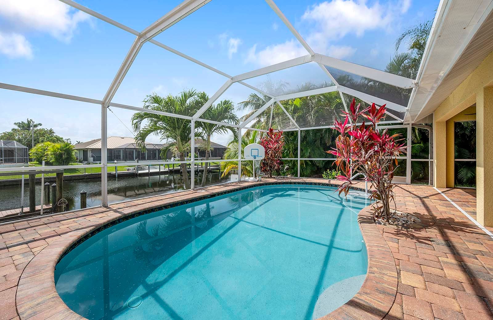 Privater Poolbereich mit Sonnenliegen und Blick auf den Kanal mit Bootsdock.