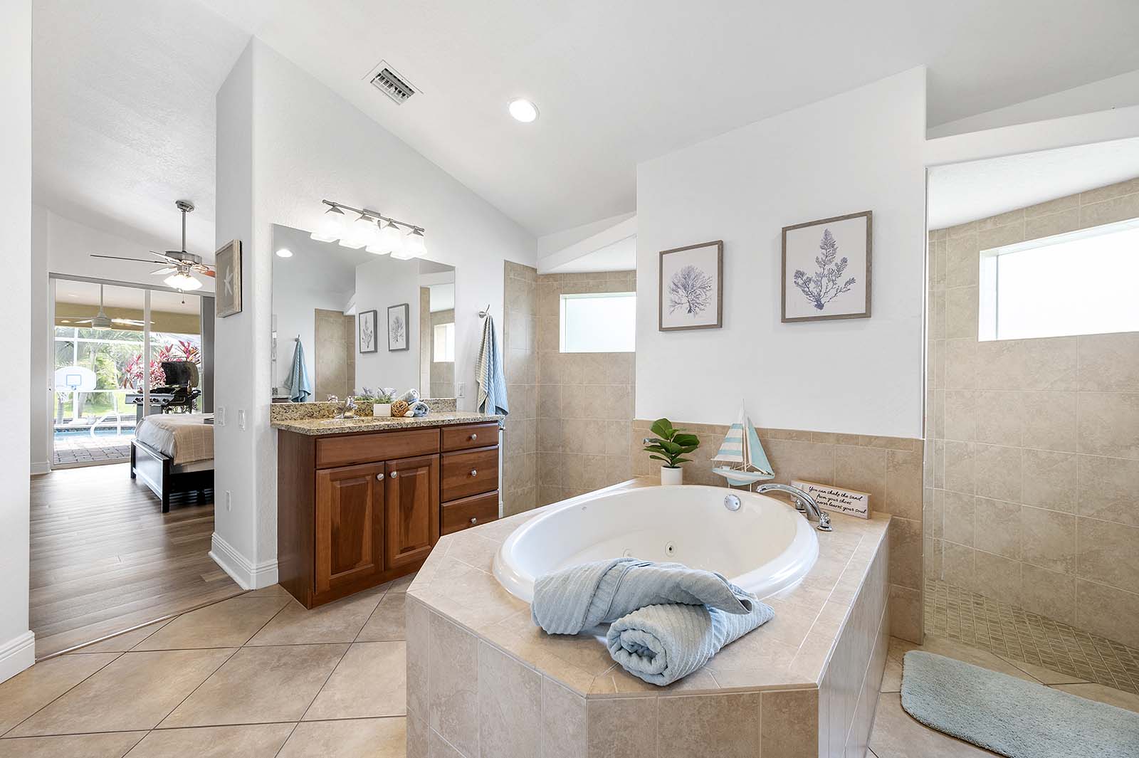 Privater Poolbereich mit Sonnenliegen und TV am Kanal.