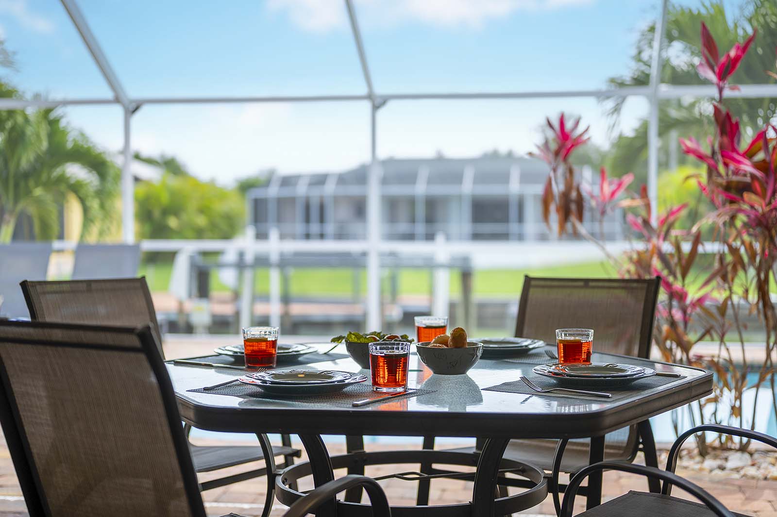 Privater Poolbereich mit Sonnenliegen und TV am Kanal mit Bootsdock.