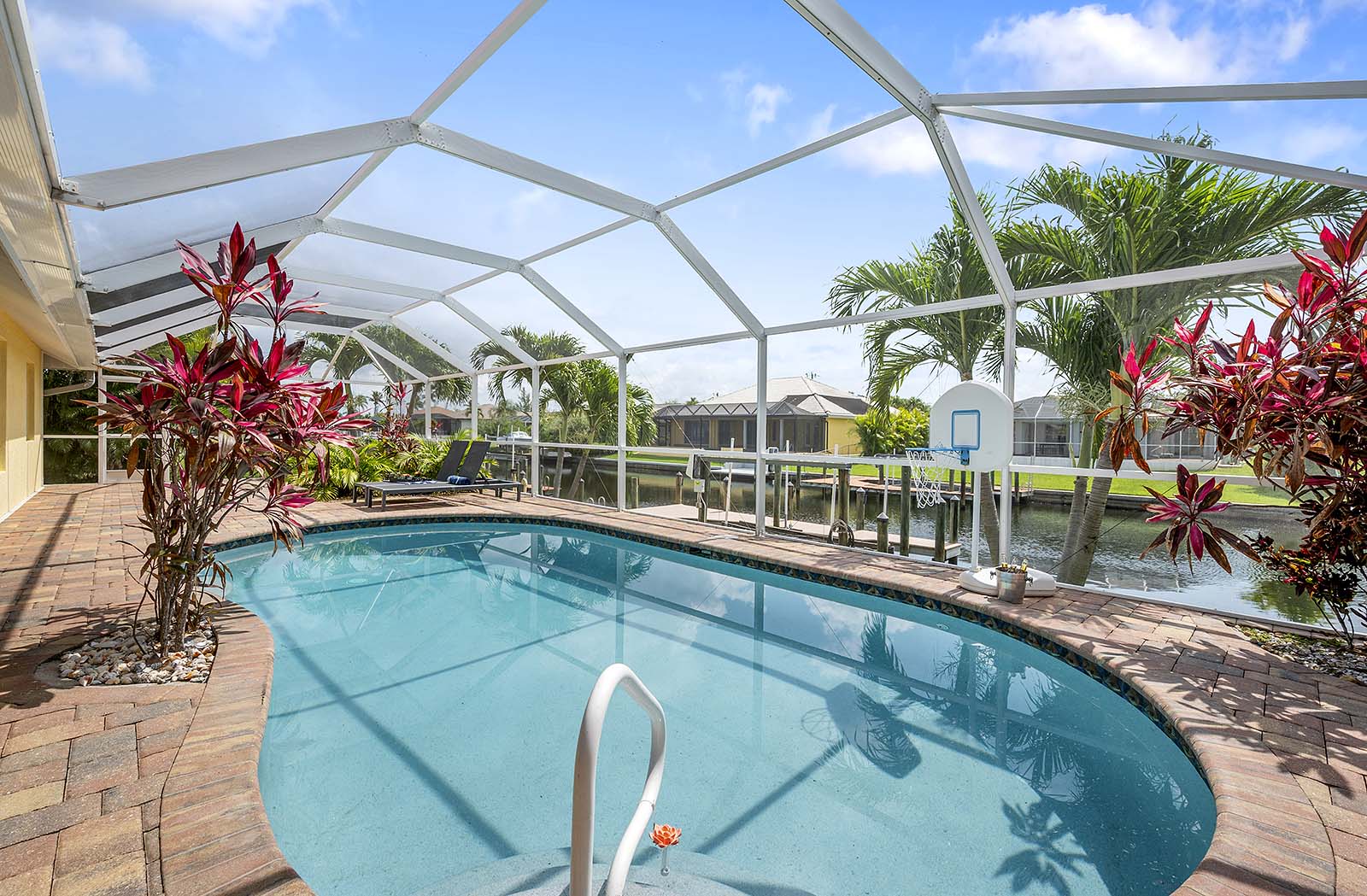 Privater Poolbereich mit Sonnenliegen und Blick auf den Kanal am Bootsdock.