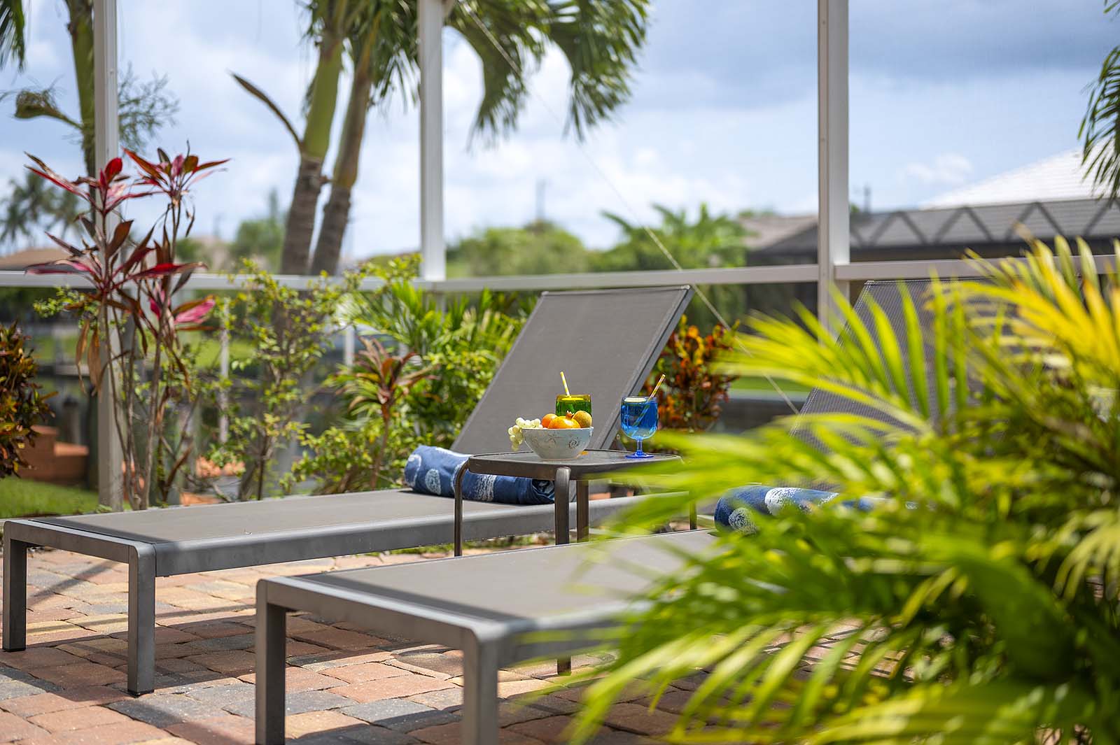 Privater Poolbereich mit Sonnenliegen und Blick auf den Kanal.