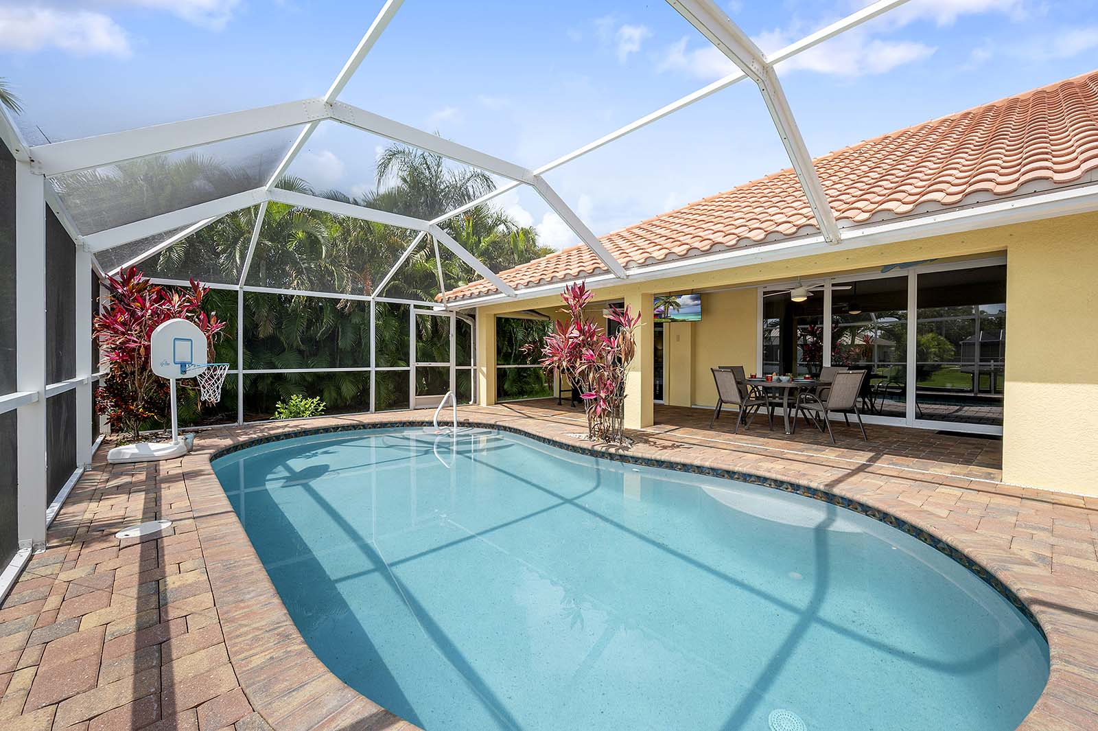 Privater Poolbereich mit Sonnenliegen und TV am Wasserkanal.