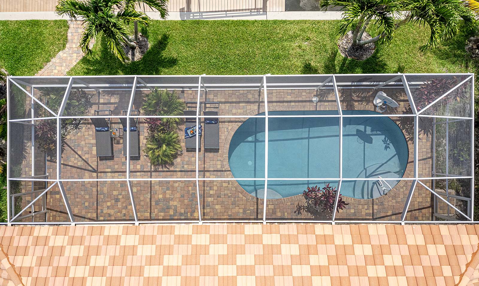 Privater Poolbereich mit Sonnenliegen und TV am Wasserkanal.