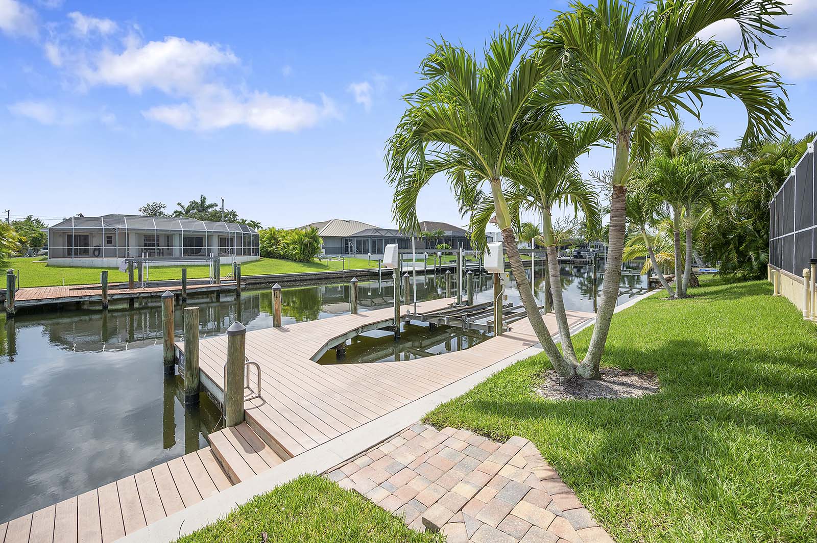 Privater Poolbereich mit Sonnenliegen am Kanal und Bootsdock.