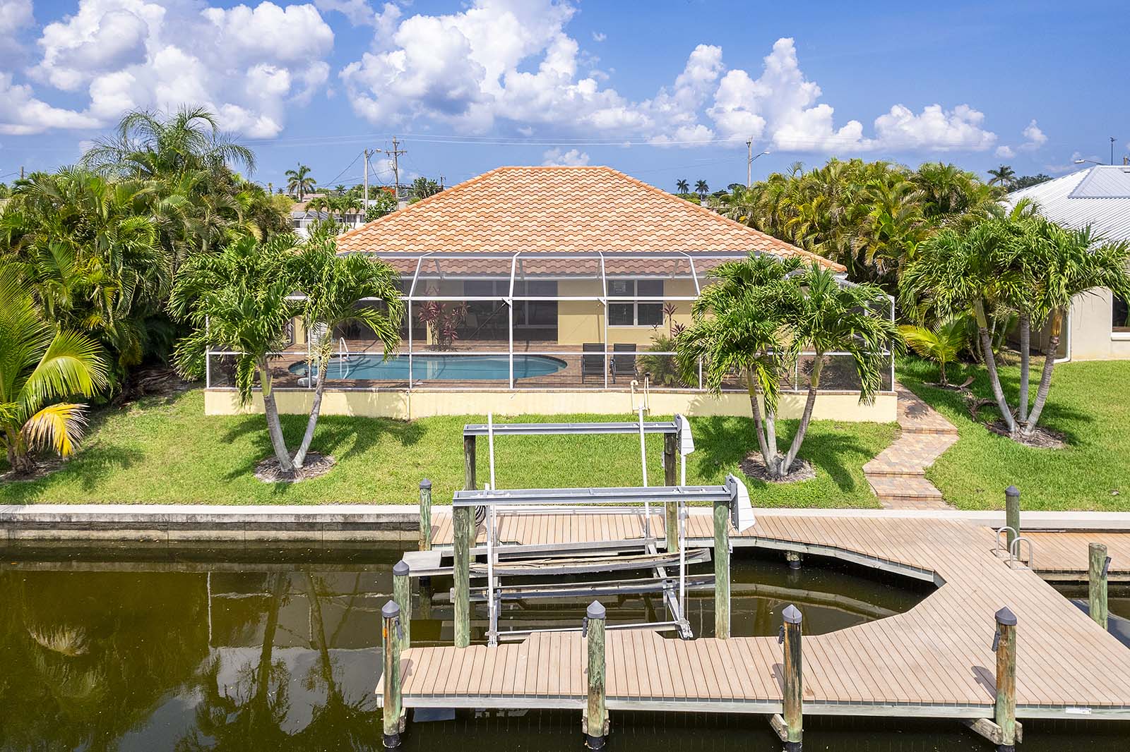 Privater Poolbereich mit Sonnenliegen und Blick auf den Kanal.