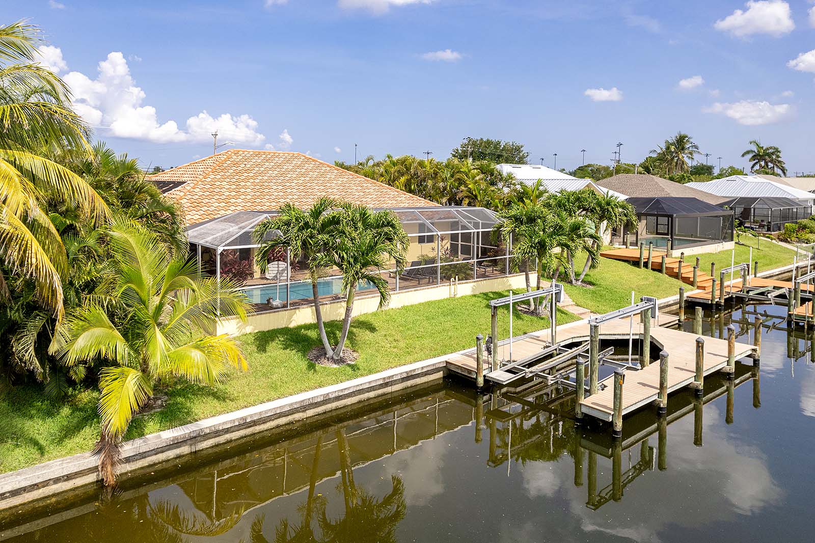 Privater Poolbereich mit Sonnenliegen und Blick auf den Kanal.