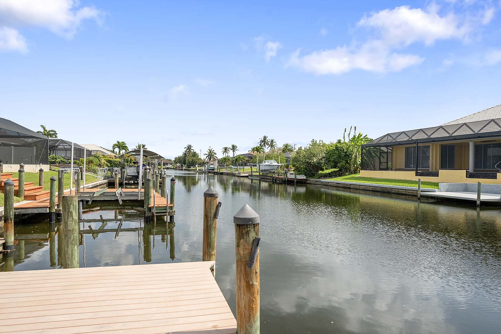 Poolbereich mit Sonnenliegen am Kanal und privatem Bootsdock.