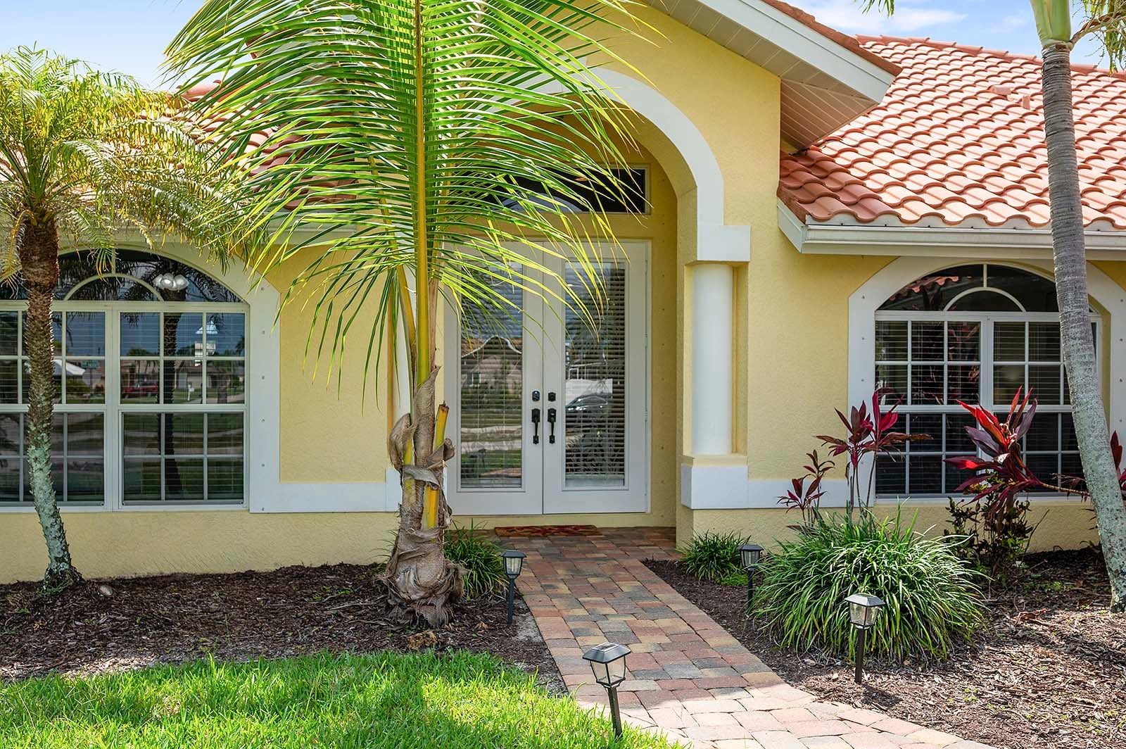 Privater Poolbereich mit Sonnenliegen und TV am Kanal.