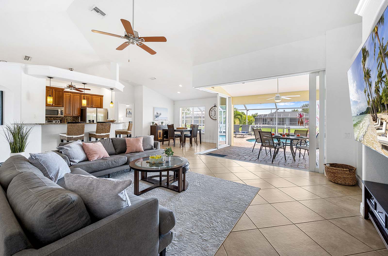 Privater Poolbereich mit Sonnenliegen und TV am Kanal.