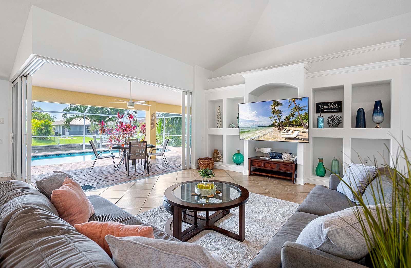 Privater Poolbereich mit Sonnenliegen und TV am Wasserkanal.