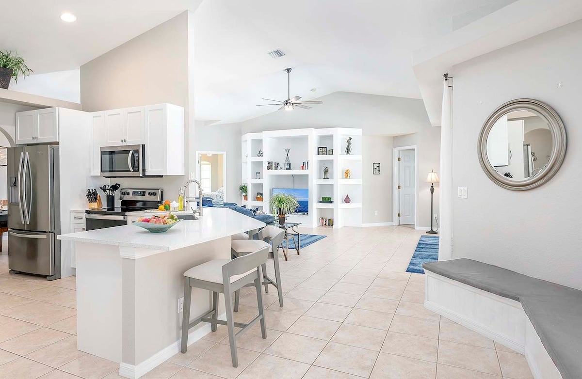 Überdachte Veranda (Lanai) mit Outdoor-Lounge und Esstisch am Pool.