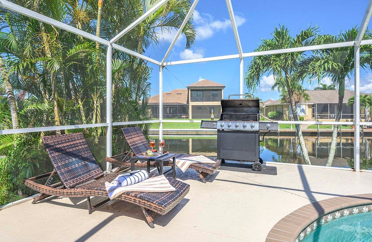 Überdachte Veranda mit Outdoor-Lounge und Esstisch am Pool.