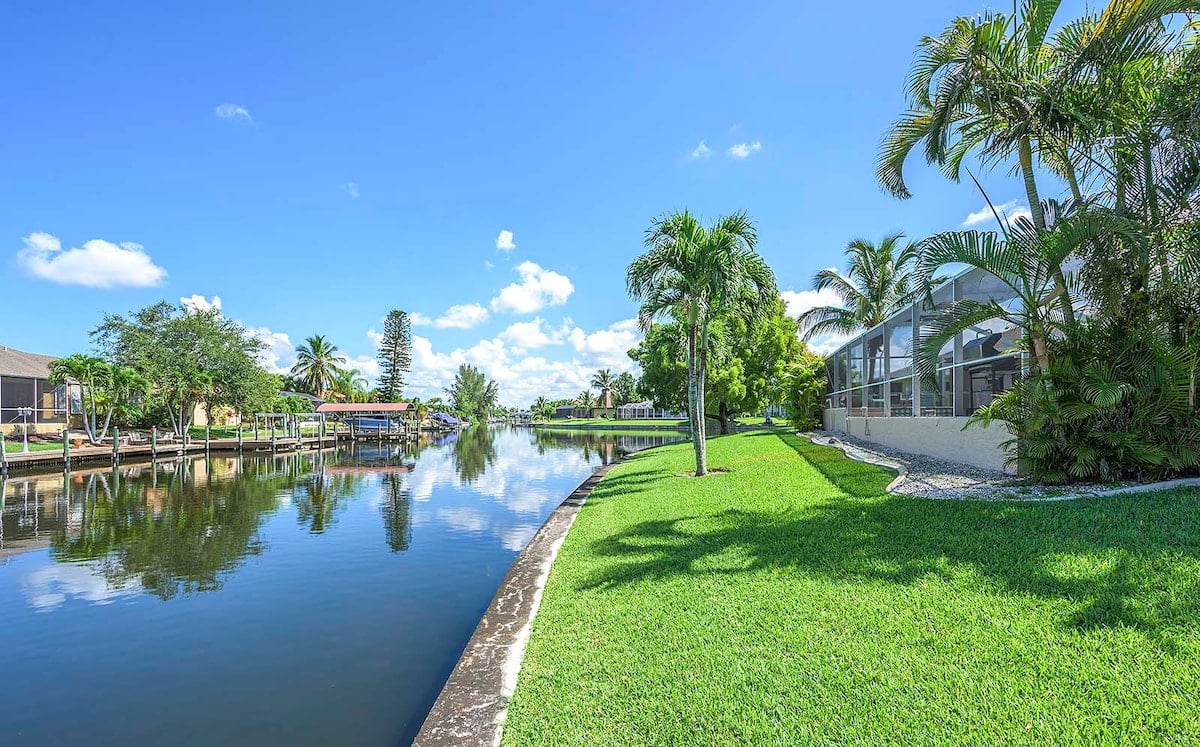 Überdachte Lanai mit Outdoor-Lounge und Essbereich am Pool.