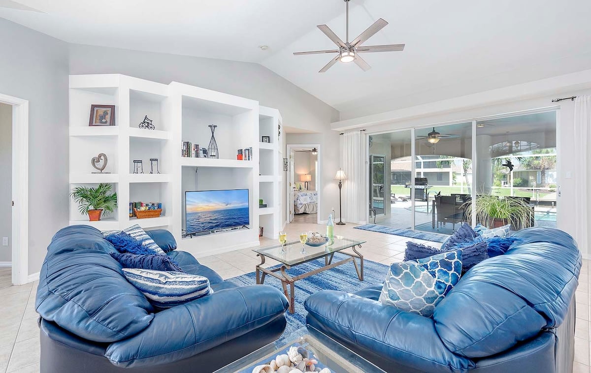 Überdachte Lanai mit Outdoor-Lounge und Esstisch am Pool.