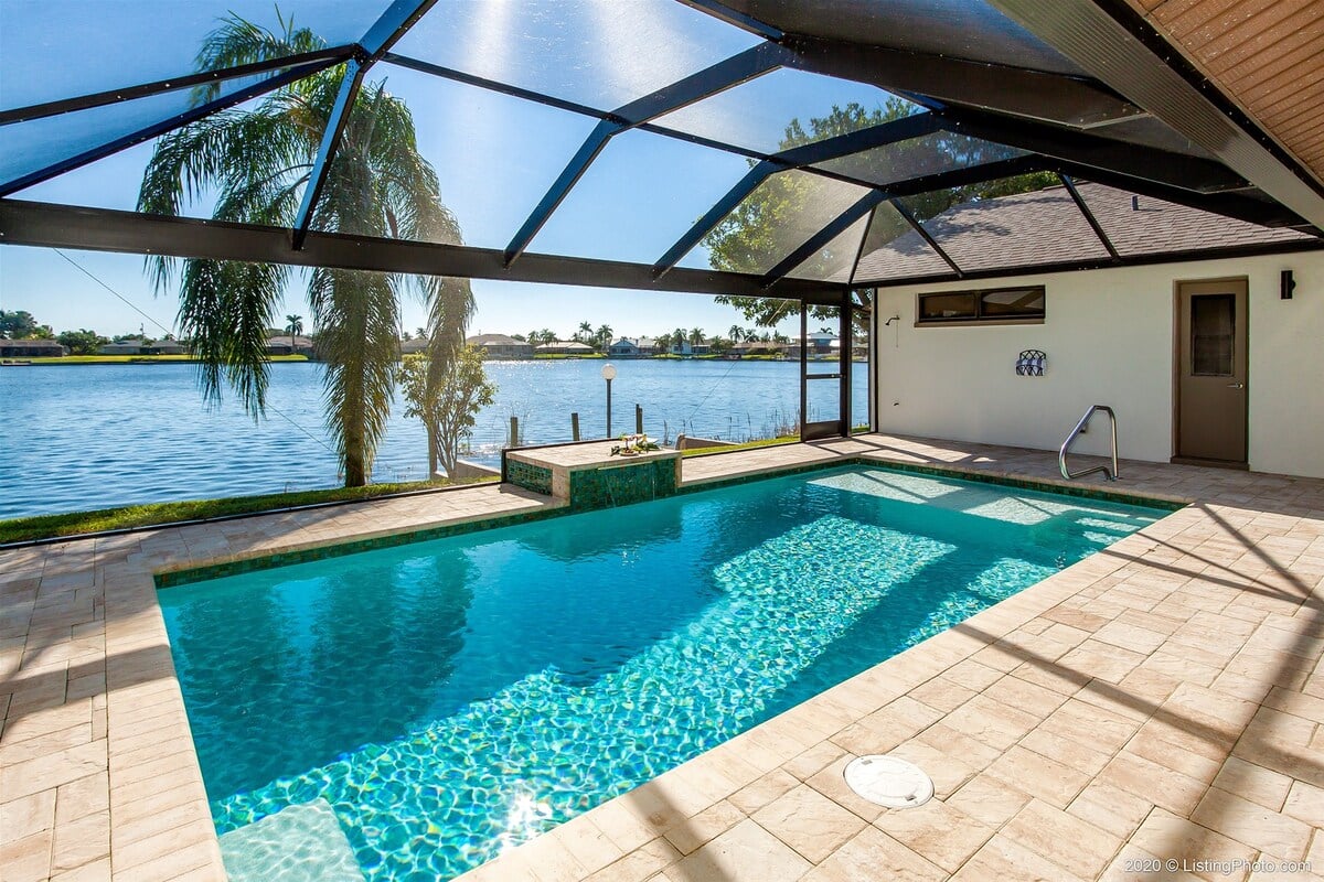 Beheizter Pool mit Sonnenliegen und Blick auf den See.