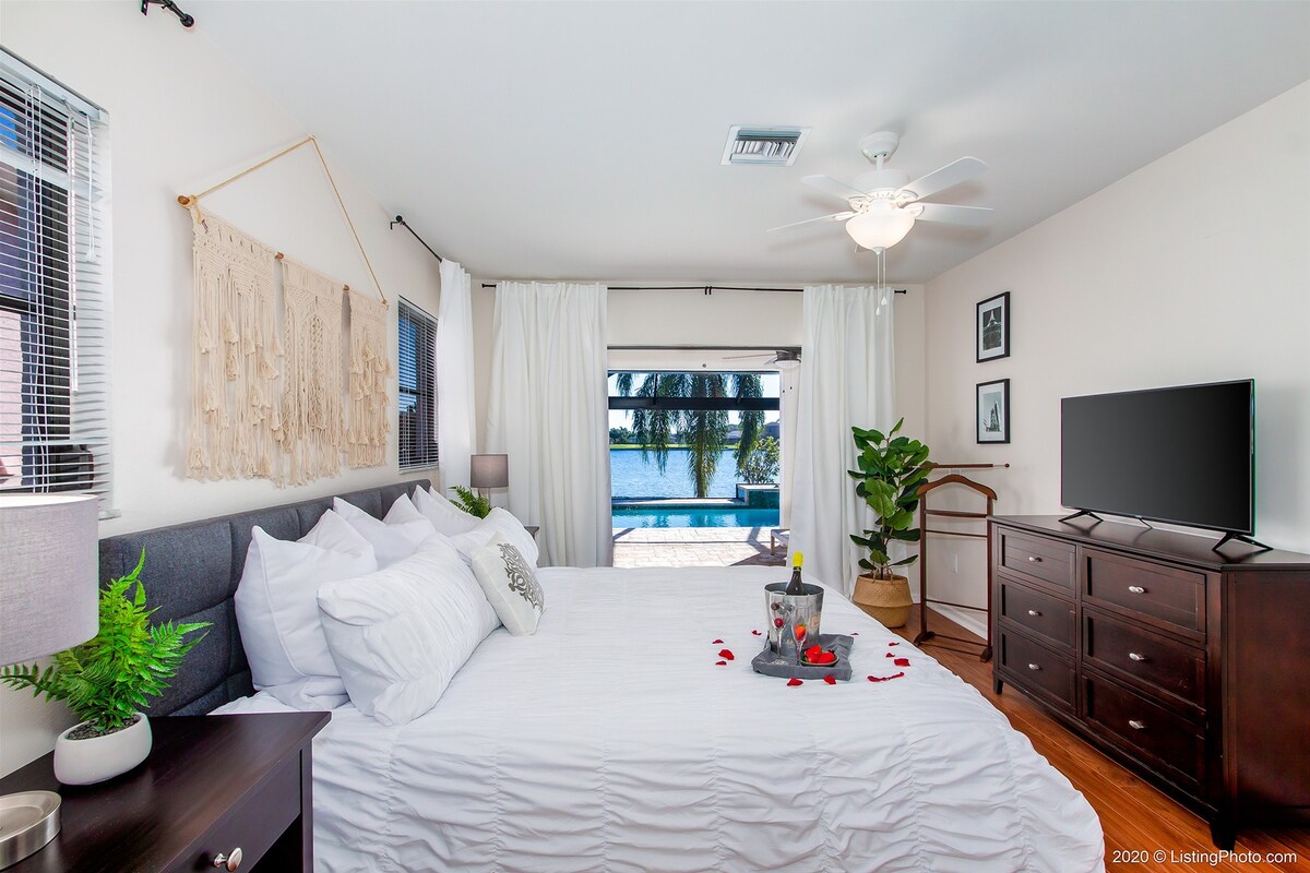 Beheizter Pool mit Sonnenliegen und Blick auf den See.