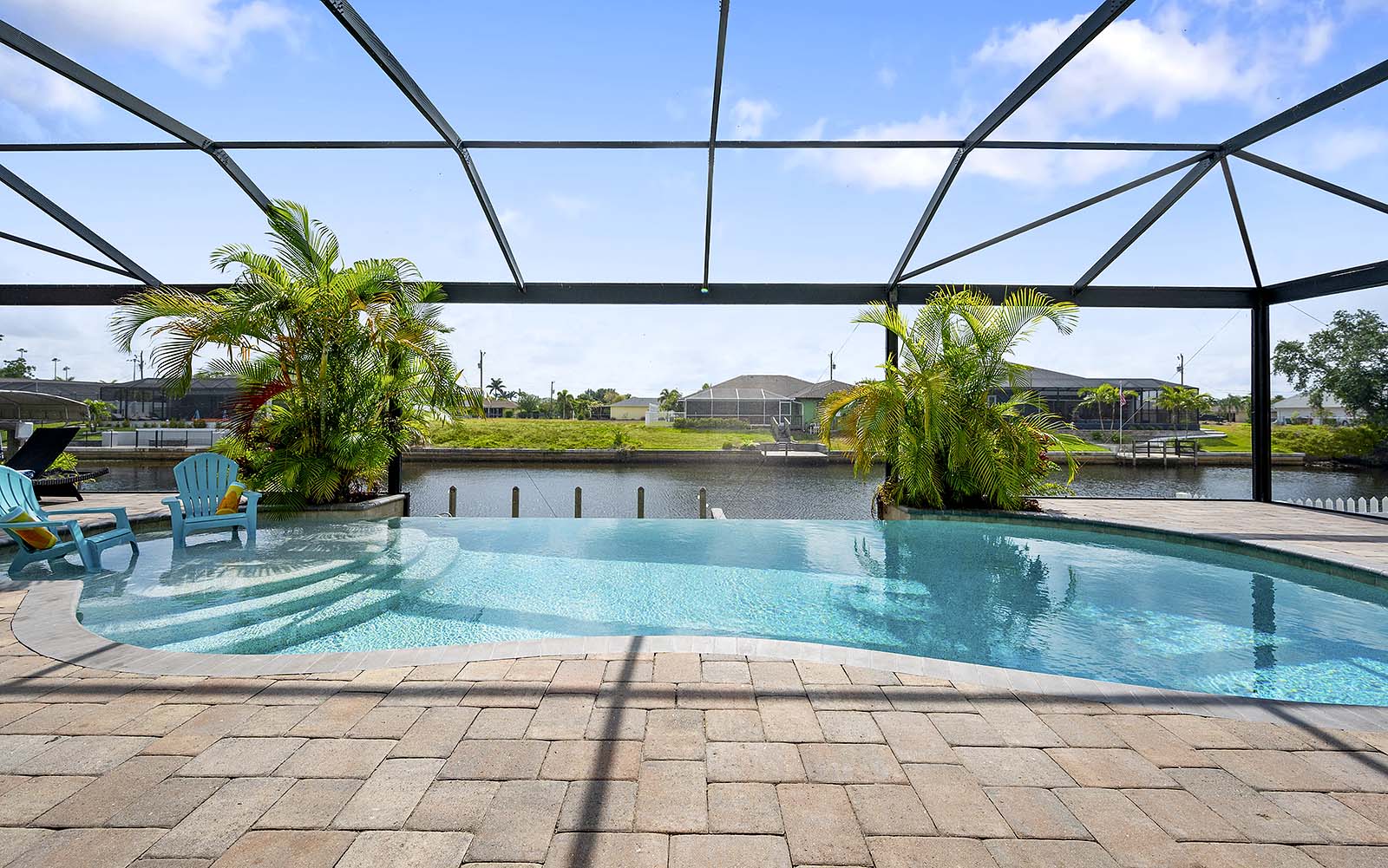 Blick auf den Kanal mit privatem Bootssteg und Terrasse am Wasser.