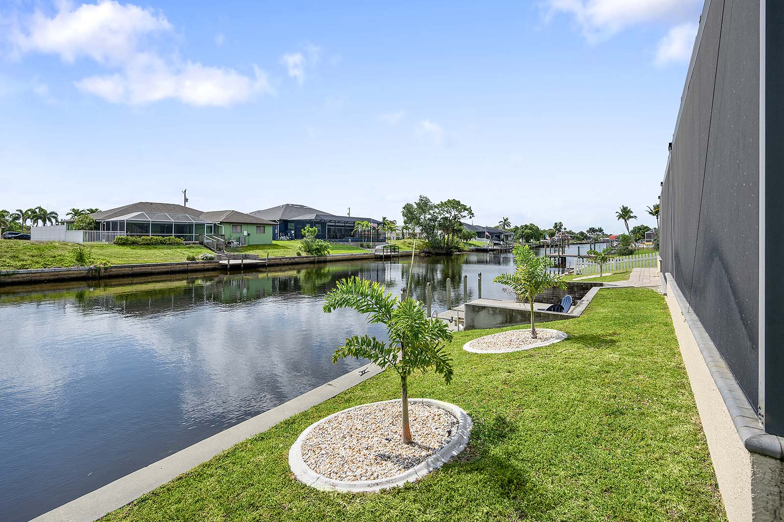Blick auf den Kanal mit privatem Bootssteg und Sitzbereich im Außenbereich.