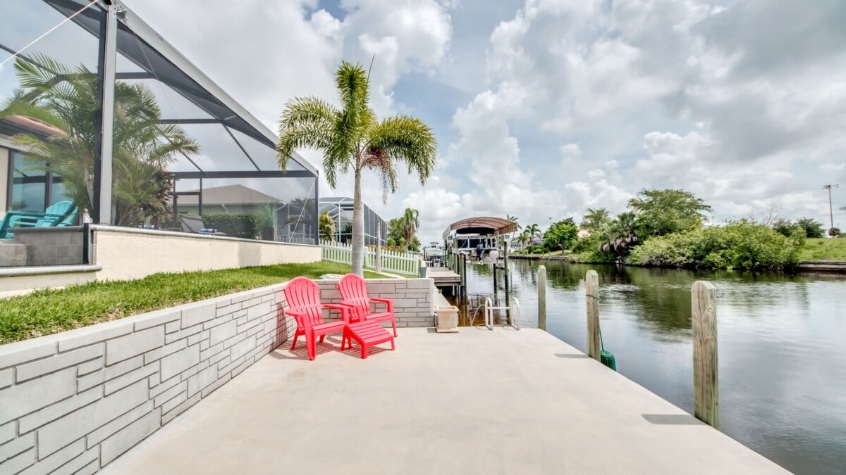 Blick auf den Kanal mit privatem Bootssteg und Sitzbereich im Außenbereich.