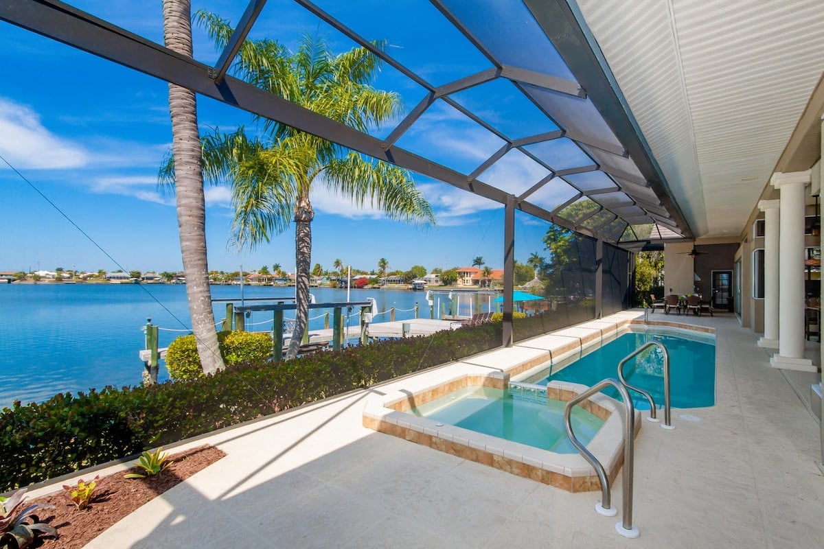 Überdachte Veranda am Kanal mit Sitzbereich und Blick aufs Wasser.