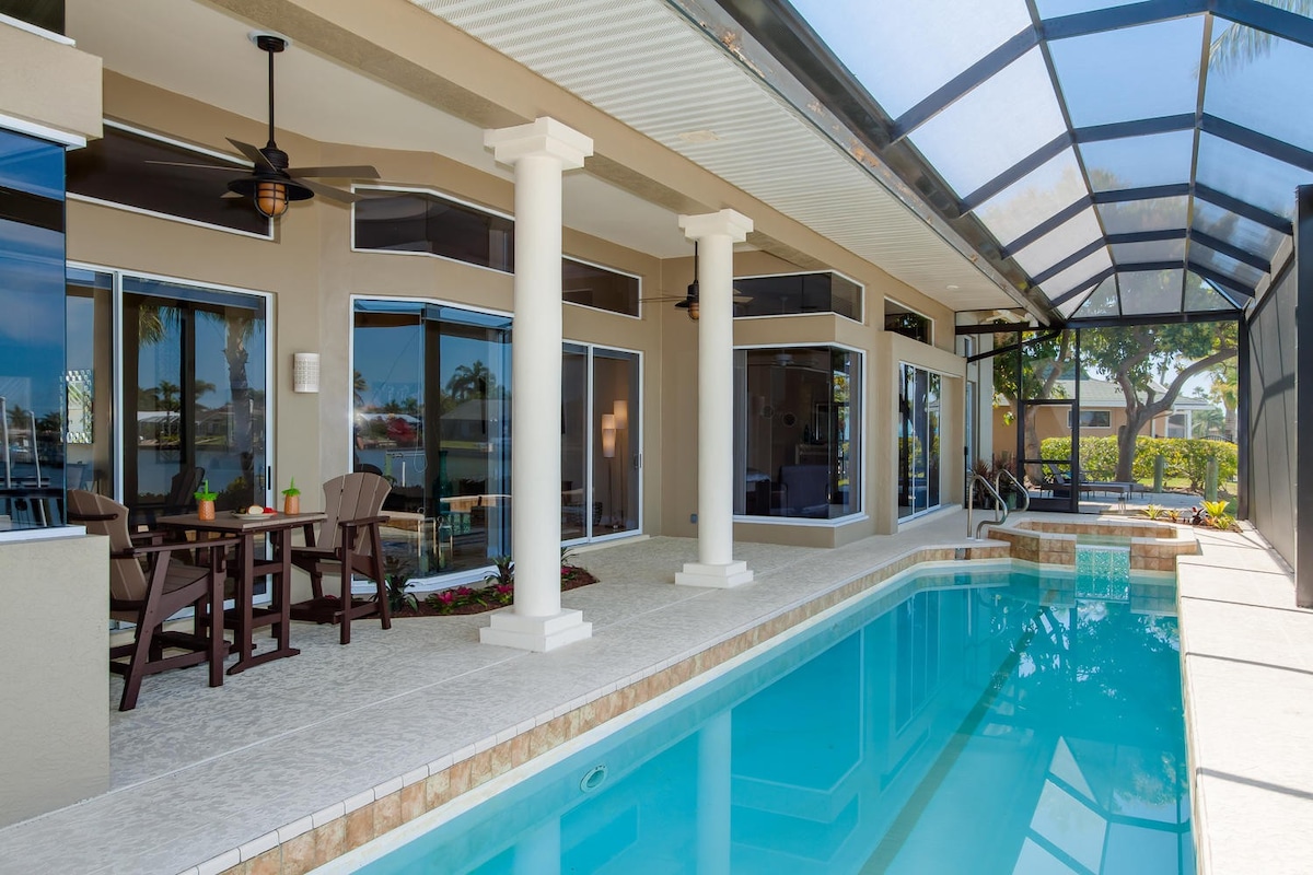 Überdachte Veranda am Kanal mit Sitzbereich und Blick aufs Wasser.