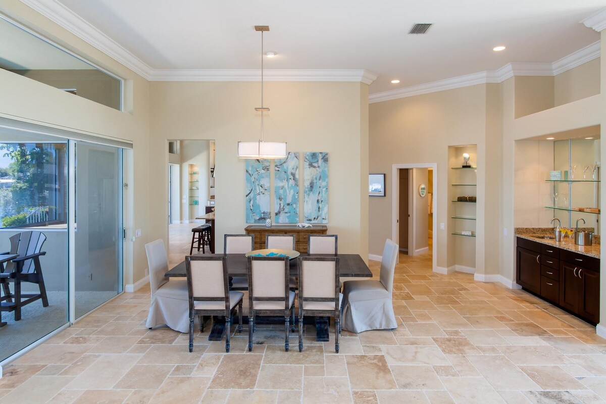 Überdachte Veranda mit Sitzbereich am Kanal bei Sonnenuntergang.