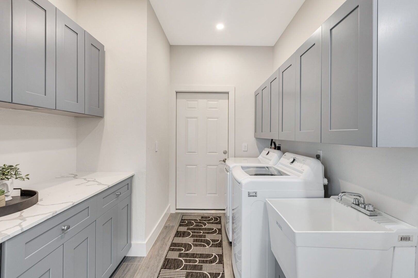 Große Lanai mit Außen-Esstisch, Sonnenliegen und Blick auf den Kanal.