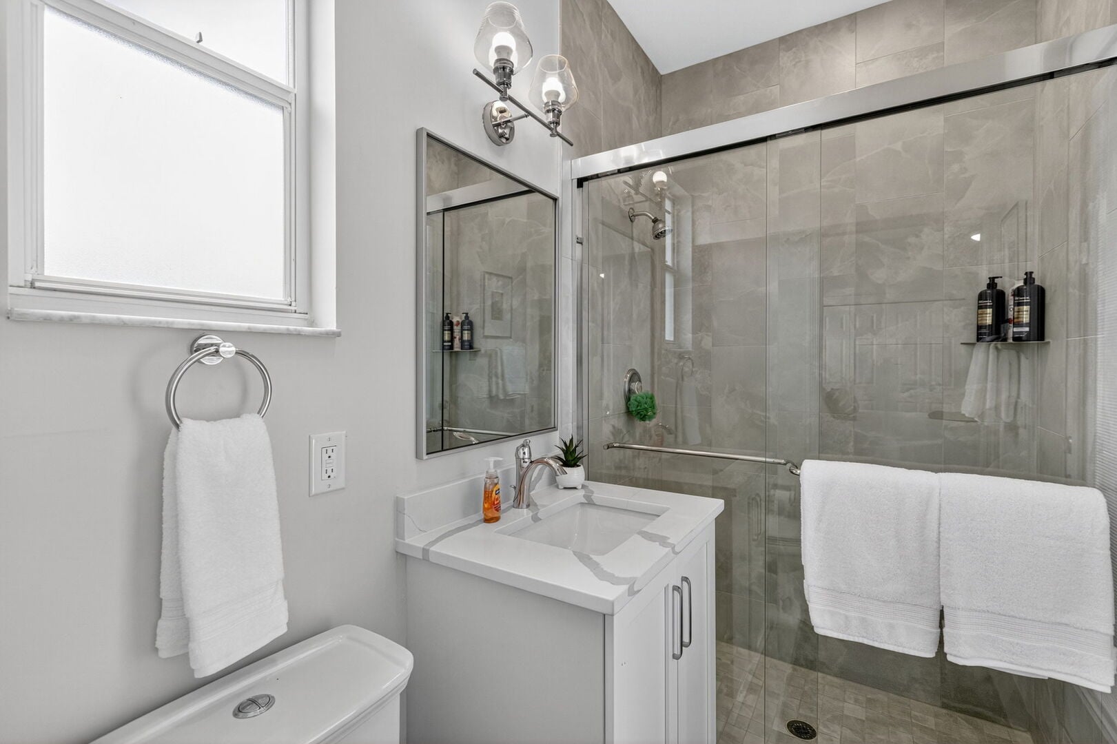 Große Lanai mit Außen-Esstisch, Sonnenliegen und Blick auf Pool und Kanal.