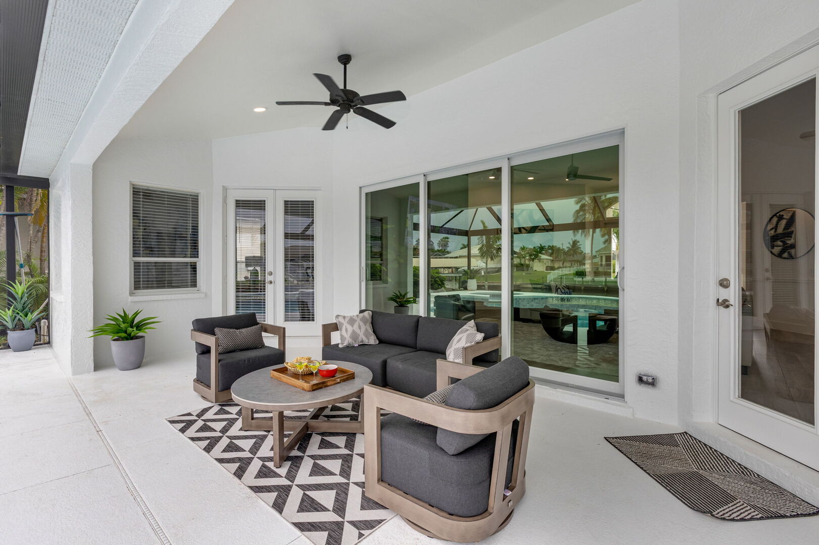 Große Lanai mit Außen-Essbereich, Sonnenliegen, Grill und Blick auf den Kanal.