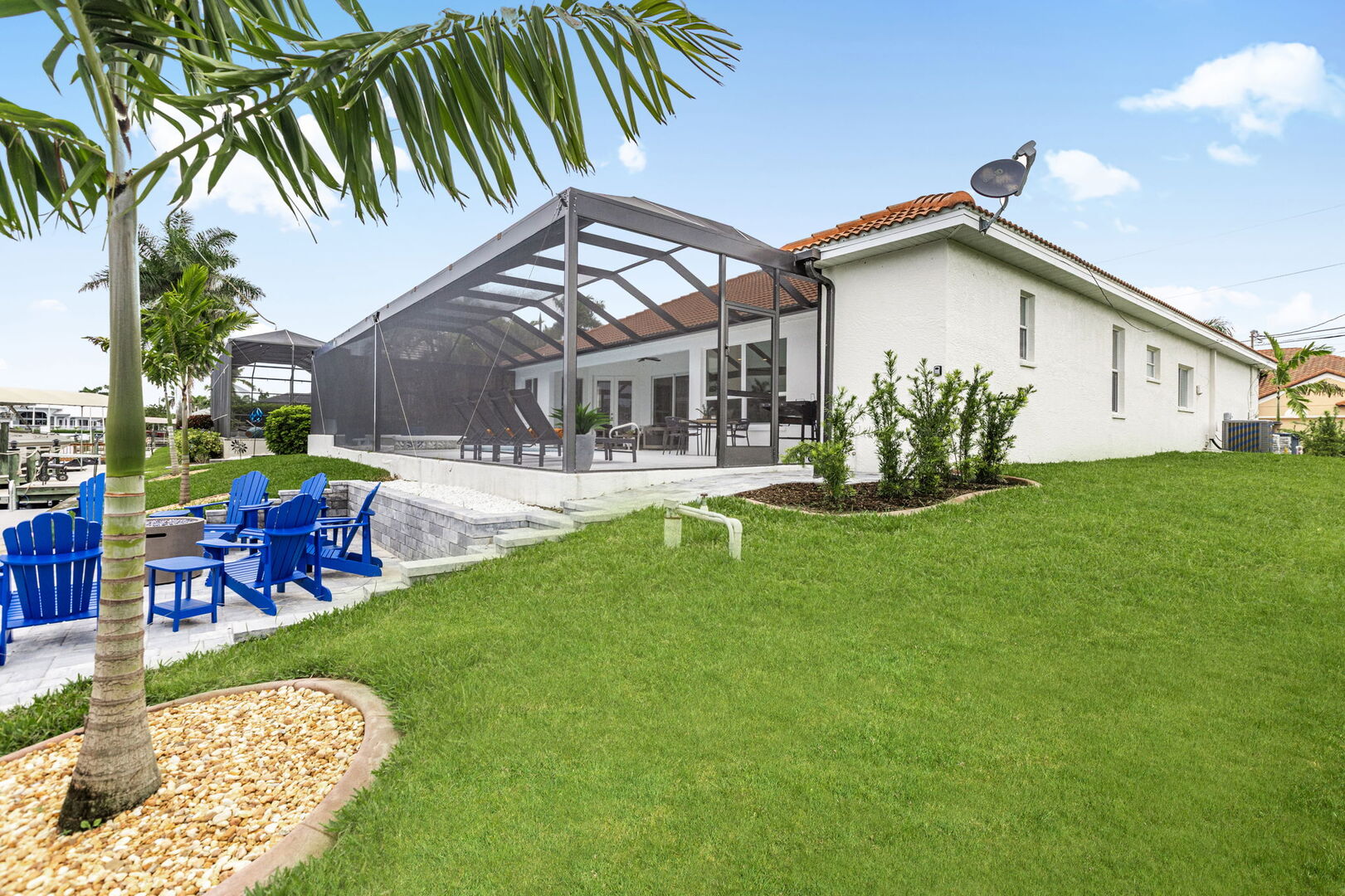 Große Lanai mit Esstisch, Sonnenliegen und Blick auf den Kanal.