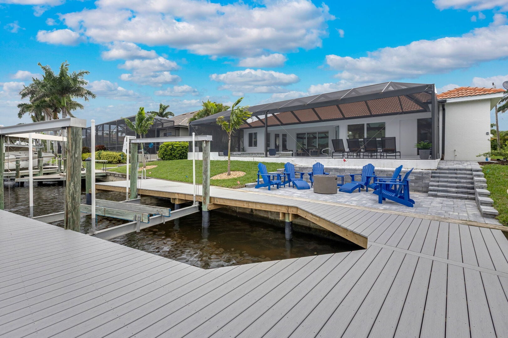 Große Lanai mit Esstisch, Sonnenliegen und Blick auf den Kanal.