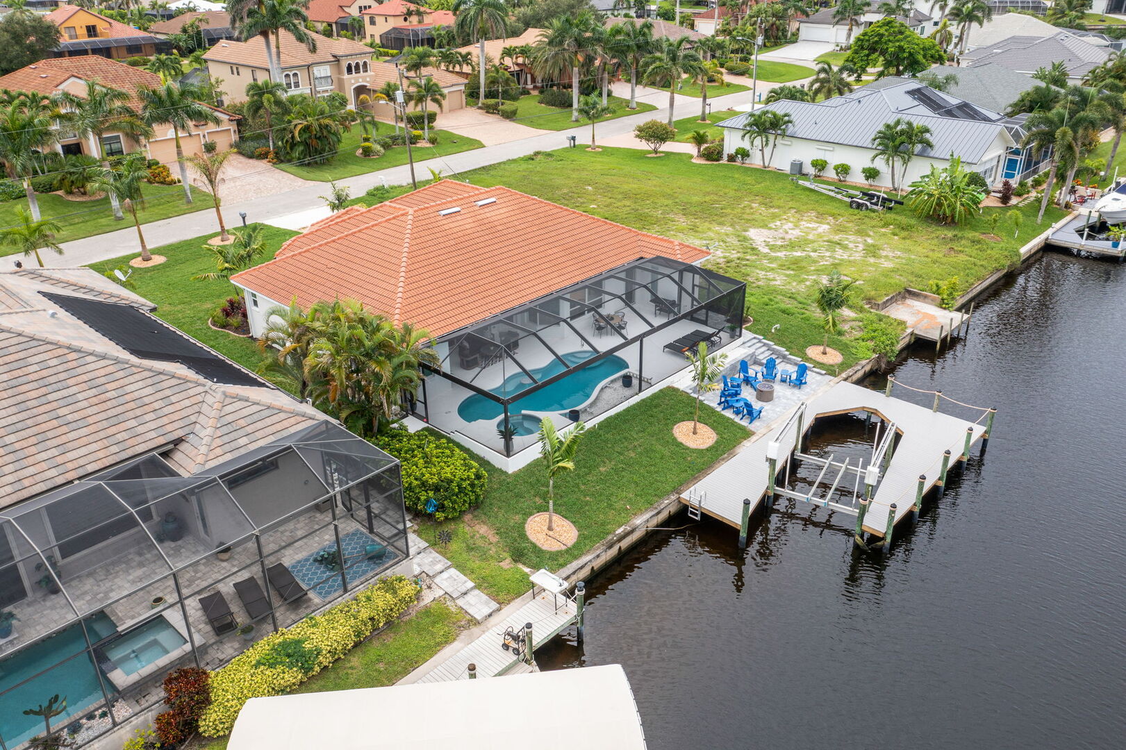 Große Lanai mit Esstisch, Sonnenliegen und Blick auf den Kanal.