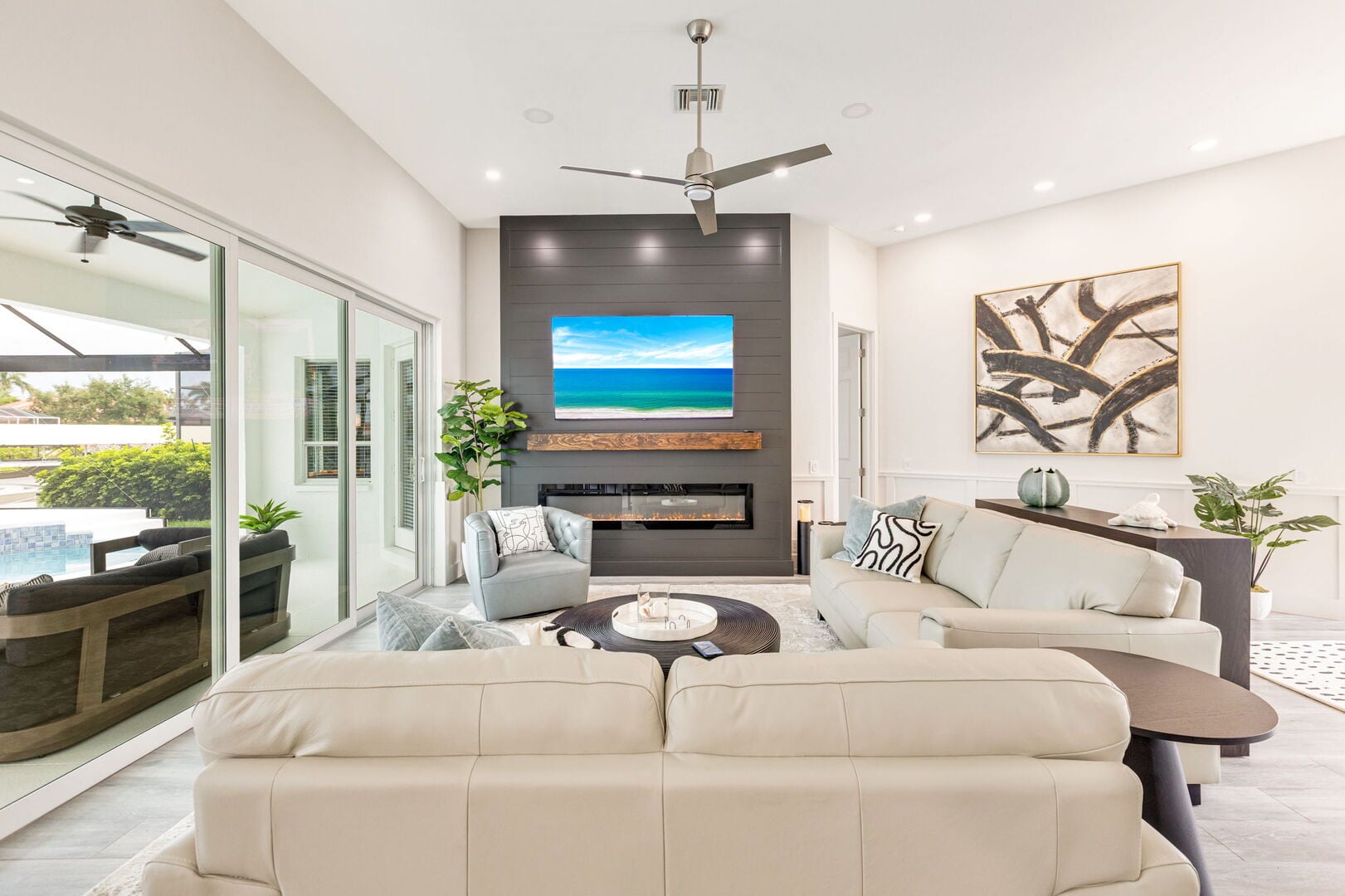 Große Lanai mit Esstisch, Sonnenliegen und Blick auf Pool und Kanal.