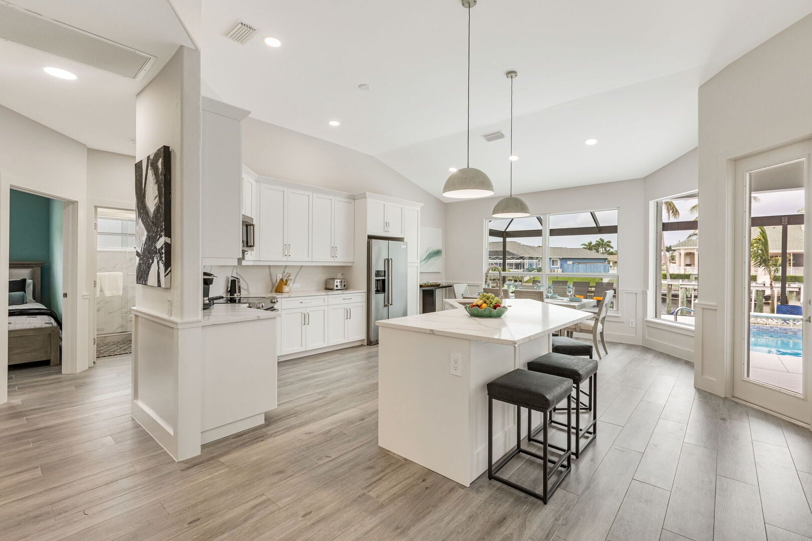 Große Lanai mit Außen-Esstisch, Sonnenliegen, Grill und Blick auf den Kanal.